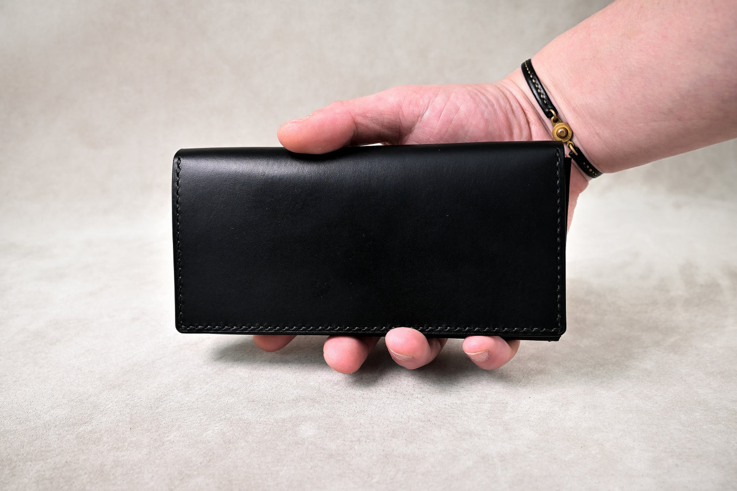 手に持った状態でブッテーロのコンパクト長財布を撮影(サイズ感と外装の艶が伝わる)