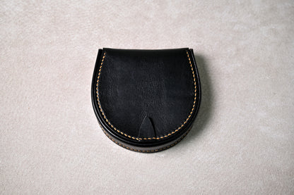 ブッテーロのブラックの馬蹄型コインケース「shihu」を真上から撮影（閉じた状態、滑らかなカーブと縫製ラインが際立つ）