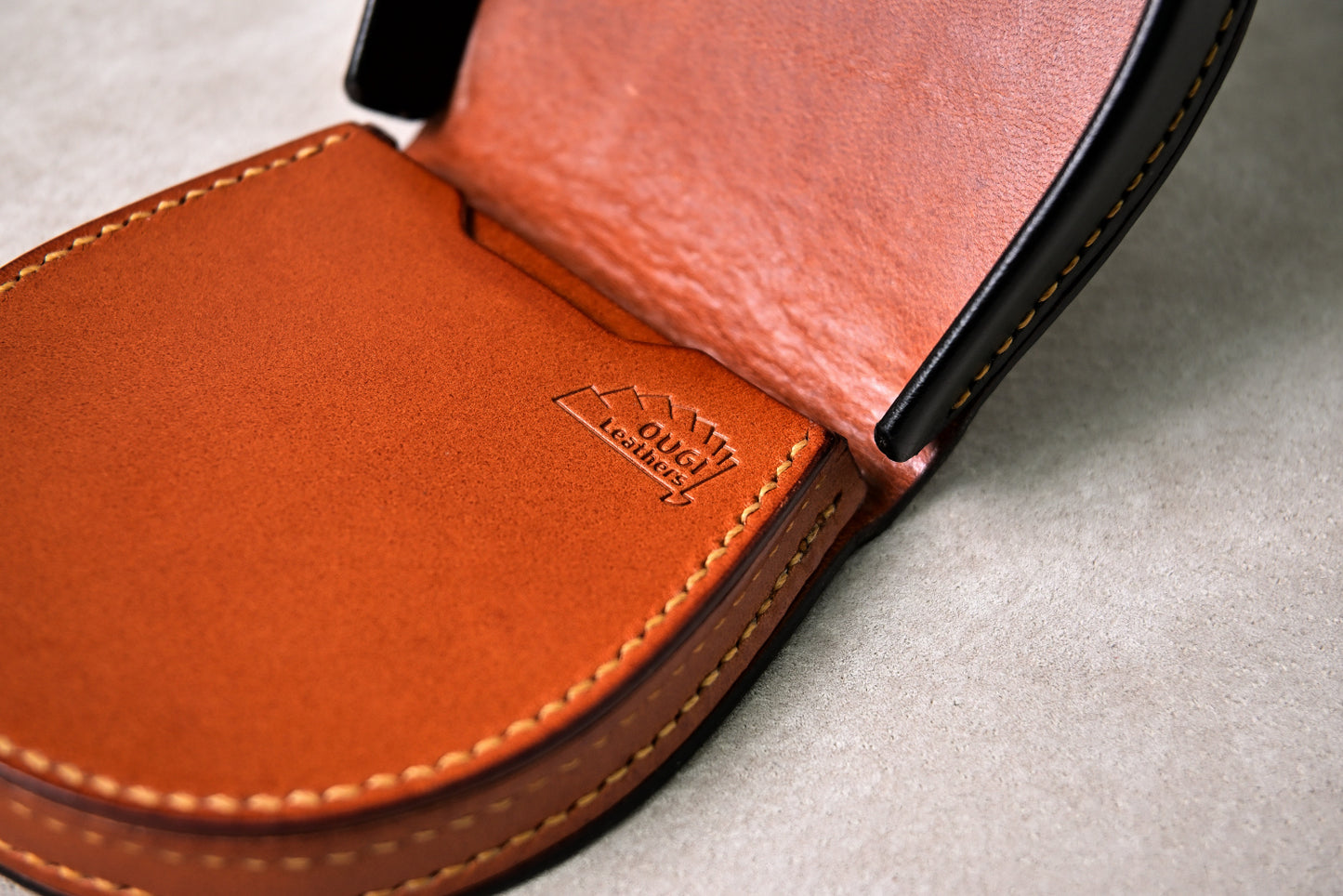 馬蹄型コインケース「shihu」の内装ロゴを接写（ブッテーロキャメルにOUGI Leathersの刻印）
