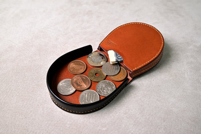 コインを収納した馬蹄型コインケースを開いた状態で撮影（実際の使用感、小銭の視認性と取り出しやすさが伝わる）