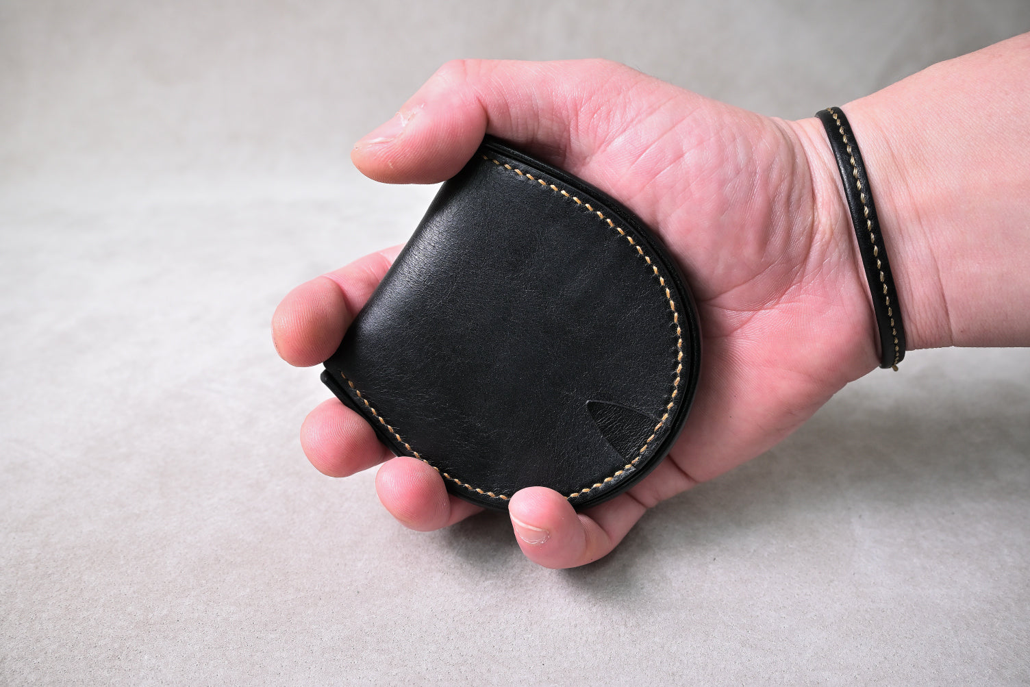 手に持った状態の馬蹄型コインケースを撮影（サイズ感とフィット感を直感的に表現）