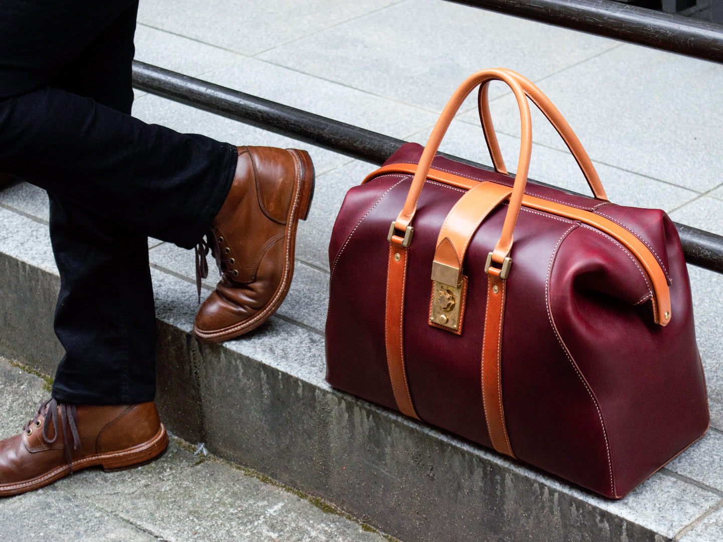 ボルドーとキャメルの口金式レザーボストンバッグを街角で撮影（植物タンニンなめし、手縫い）