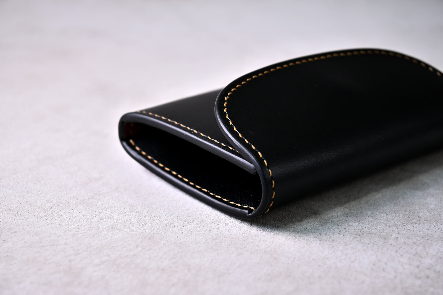 フラップと側面のコバ部分を接写で撮影（エッジが滑らかに磨かれ、蝋仕上げされた丁寧な仕立て）