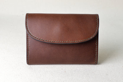 ブッテーロのブラウンとグリーンで仕立てたTetoコインケースを正面から撮影（手縫い、クラシックな配色）