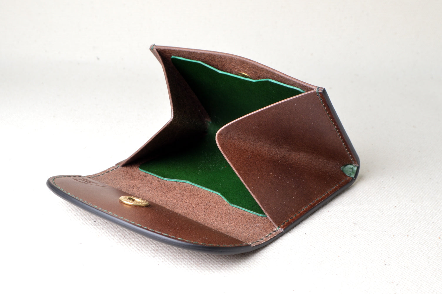 内装グリーンのホック式コインケースを開いた状態で撮影（マチ付き構造、手縫い、ブッテーロ使用）