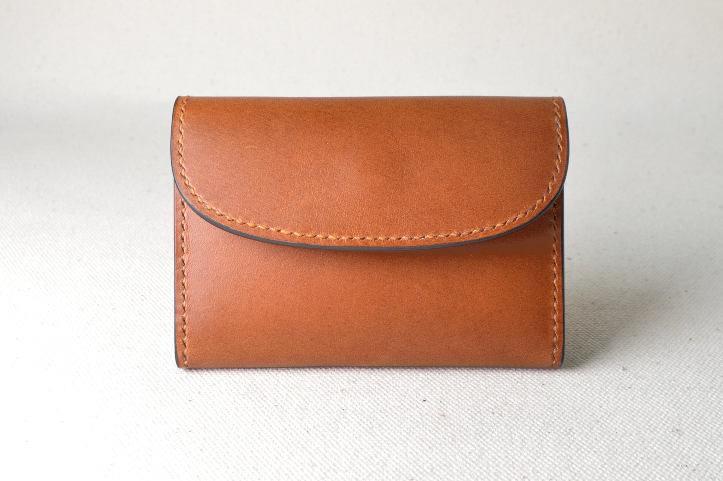 ブッテーロのキャメルとブラウンで仕立てたTetoコインケースを正面から撮影（アクセントにオレンジの仕切り）