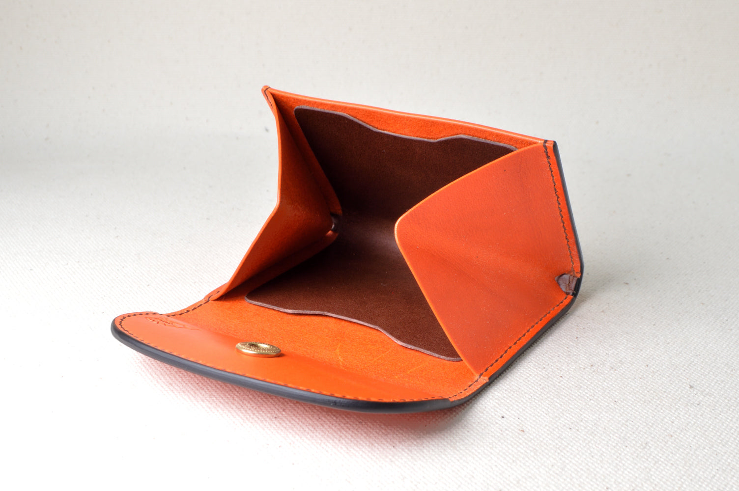 内装ブラウンでまとめたホック式コインケースを開いた状態で撮影（マチ付き、ブッテーロの深みある艶）