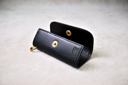 開いた状態でブランドロゴが見えるキーケースを斜めから撮影（真鍮ホック、手縫い）