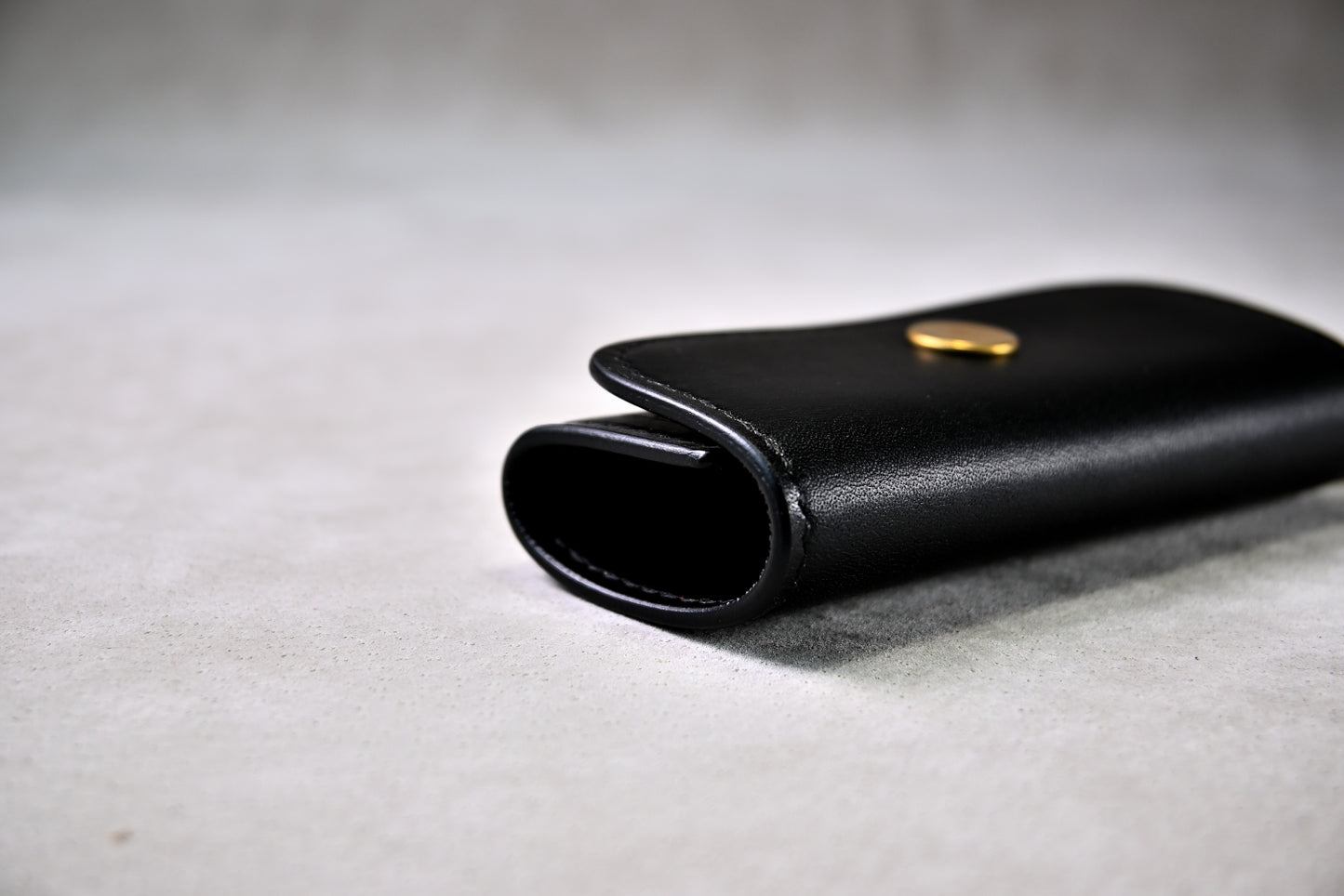 閉じたキーケースの側面を接写（ブッテーロのハリ感と手縫い仕上げ）