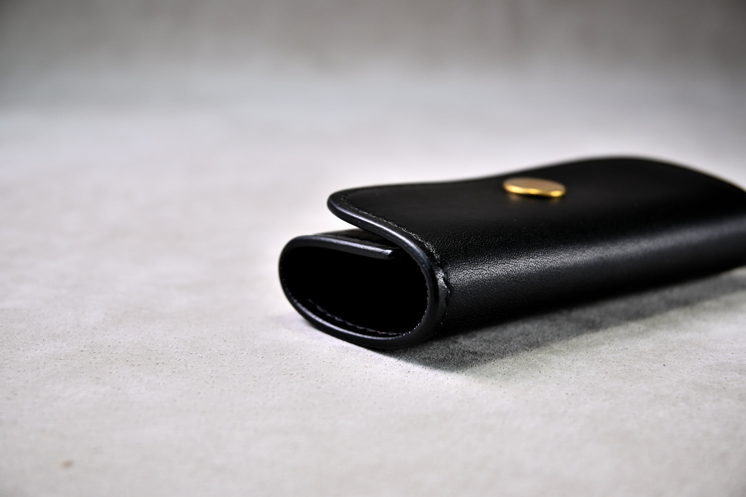 閉じたキーケースの側面を接写（ブッテーロのハリ感と手縫い仕上げ）