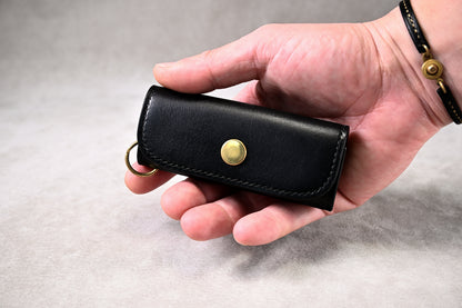 手に持ったブッテーロブラックのキーケース（真鍮ホックの存在感、サイズ感の比較）